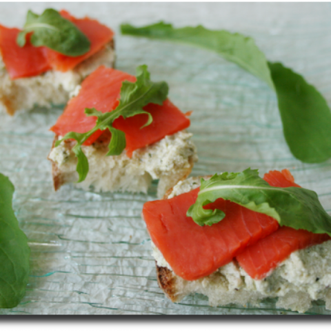 Crostini di ricotta aromatizzata al pesto, rughetta e salmone affumicato
