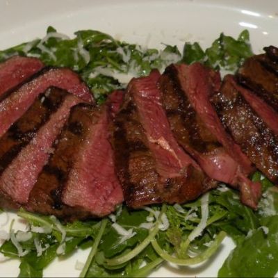 Tagliata di manzo su letto di rucola e grana con aceto balsamico