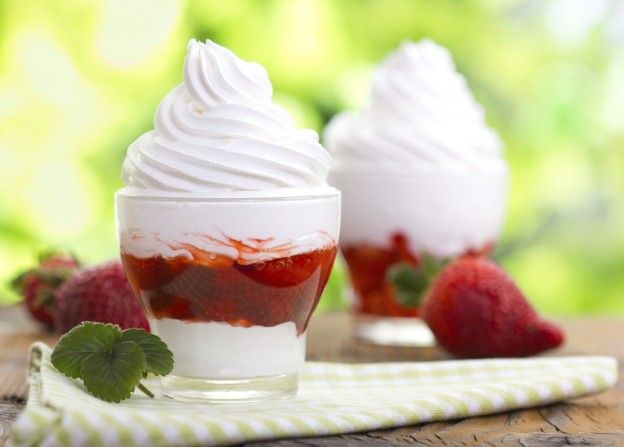 Coppe di yogurt gelato con salsa alle fragole.