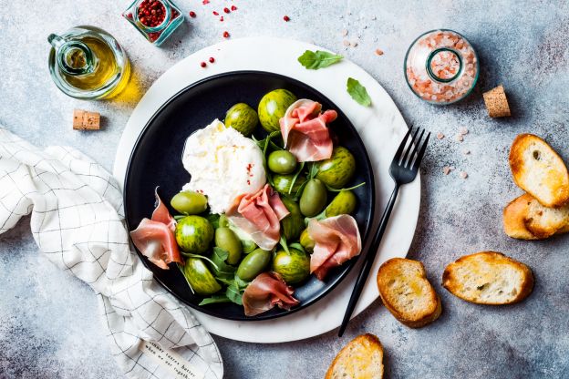 Insalata fantasia con pomodori, olive, mozzarella e prosciutto crudo