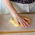 Mettete la pasta su un foglio di carta da forno e schiacciatela con la mano in modo da darle una forma circolare