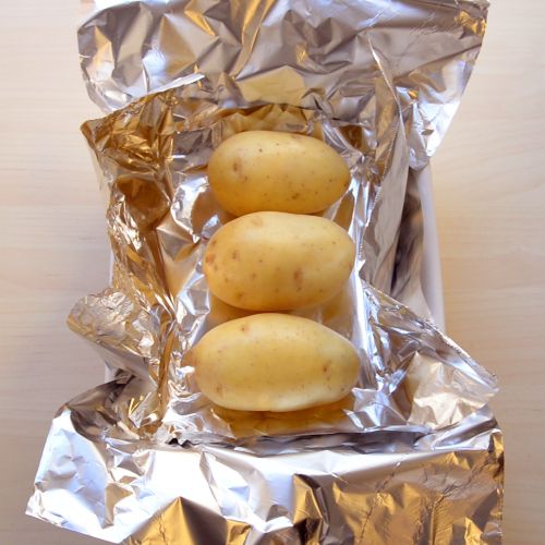 1. Rivestire di alluminio una teglia da forno, mettervi tre patate grandi
