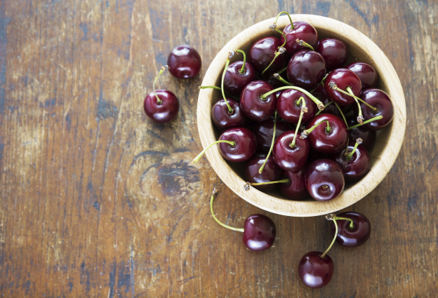 Ciliegie snocciolate con una bottiglia di birra