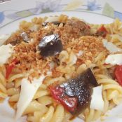 Pasta saltata alle melanzane con pomodori, salsiccia, scamorza e pane tostato