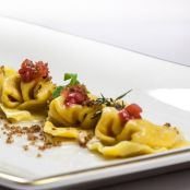 Raviolo con porri e burrata al profumo di arancia, con filetti di trota al vapore, sedano e pomodori confit di andrea mencarelli